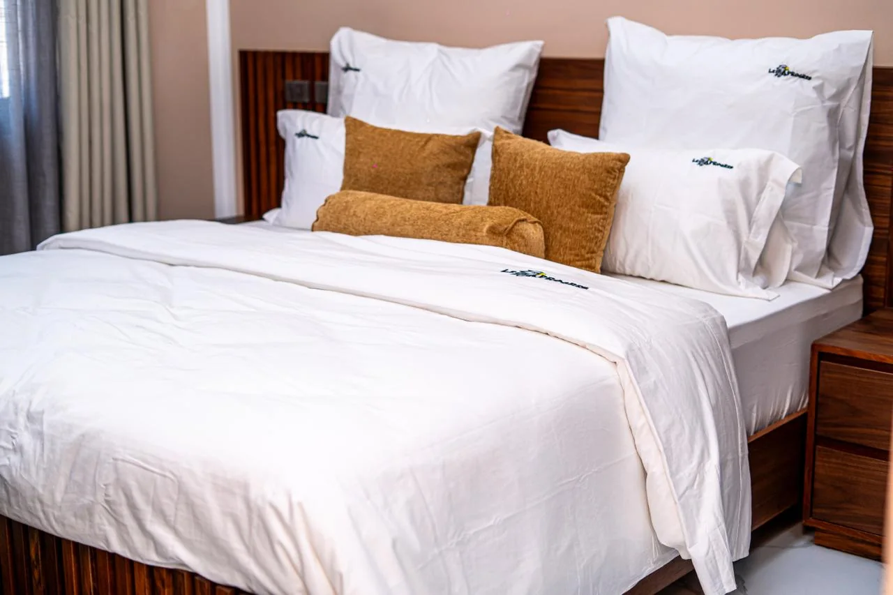 Furnished bedroom with white linen and gold cushions